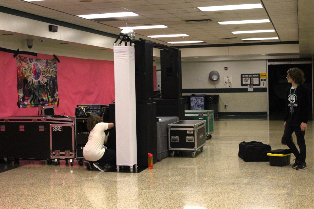 HARD AT WORK: Underclassmen set up decorations in the cafeteria around the sound system.