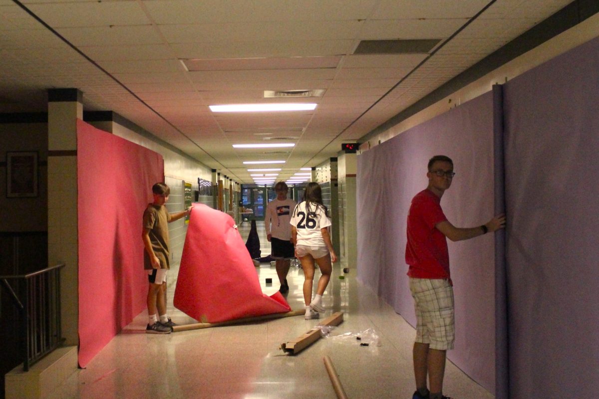 PINK & PUPRLE: Class Council members work hard to cover the walls in the dance theme colors.