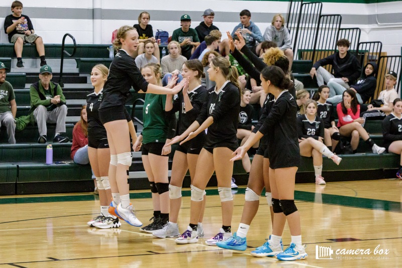 DOWN LOW: The volleyball team stands on the end line, performing their pregame ritual of high fives.