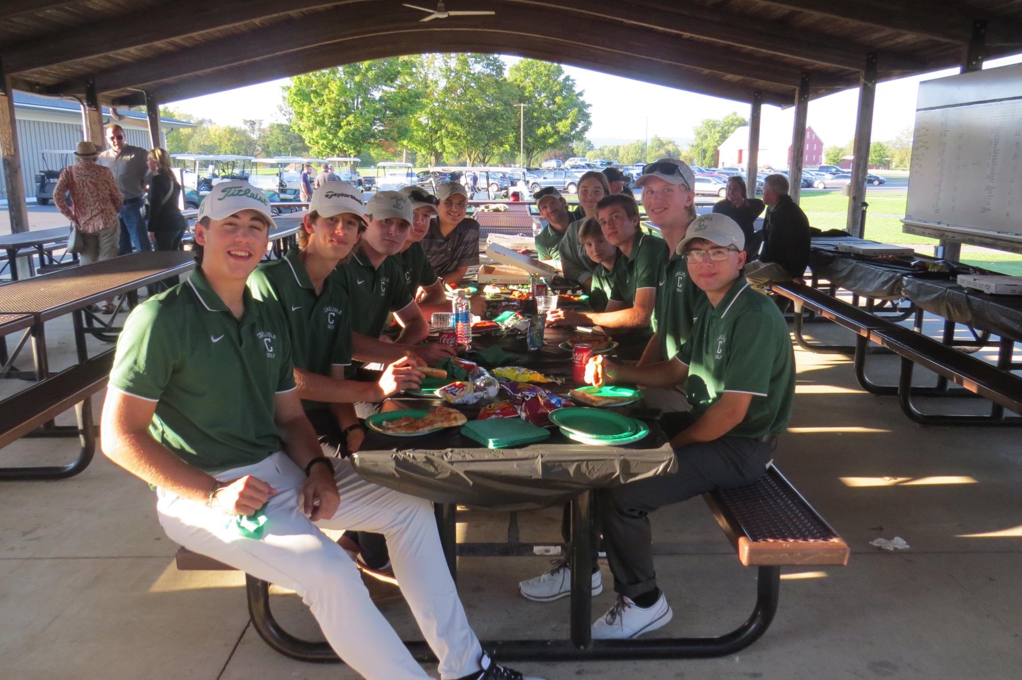 GRUBBING: The golf team celebrates their seniors with a post-match pizza party.