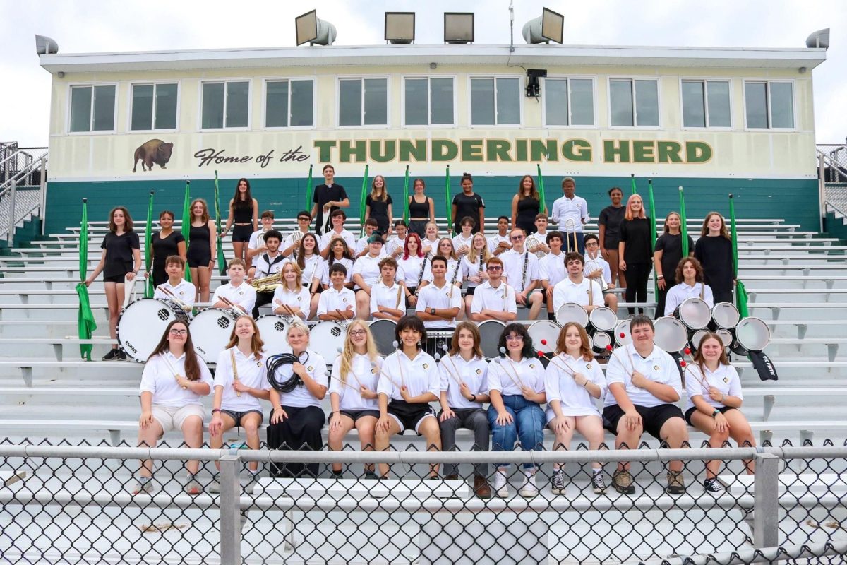 The+marching+band+stands+along+the+bleachers+for+a+team+photo.