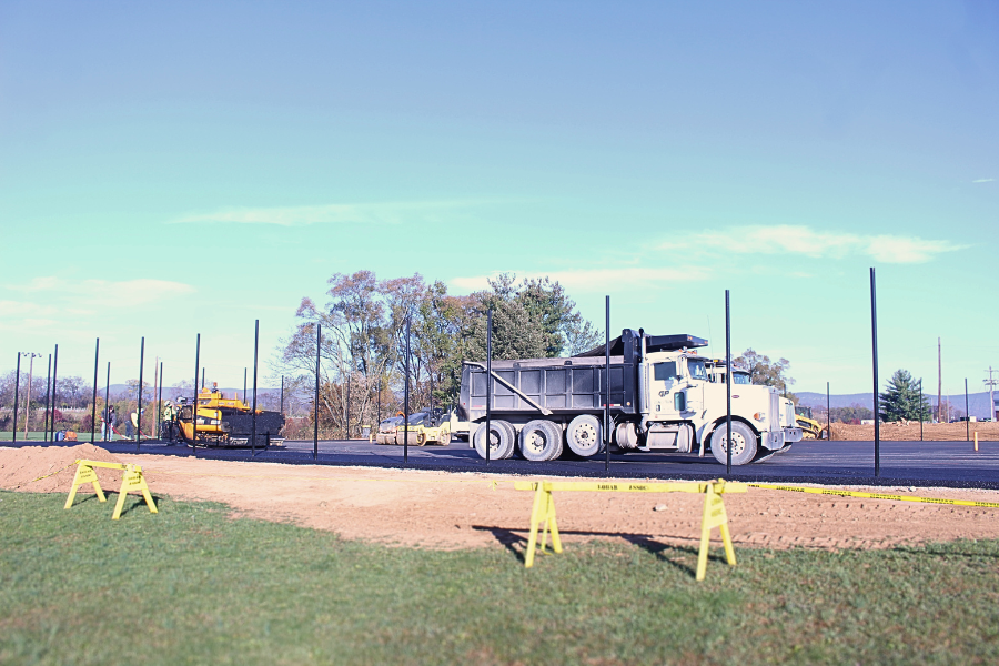 Construction+workers+are+laying+down+asphalt+for+the+new+tennis+courts.