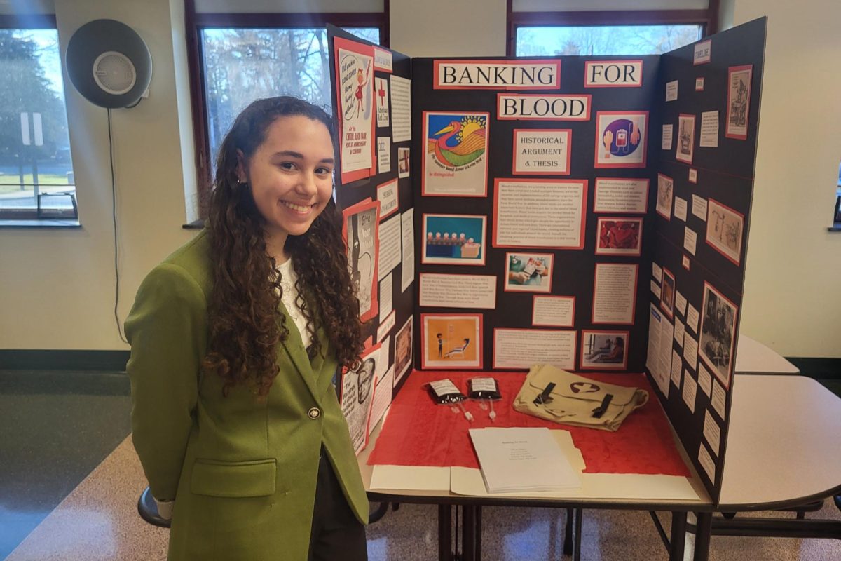 Dazzling+Display%3A+Junior+Allison+Negley+poses+with+her+2024+NHD+project.+This+is+her+third+year+in+a+row+winning+first+place+in+the+Senior+Individual+Exhibit+category.+