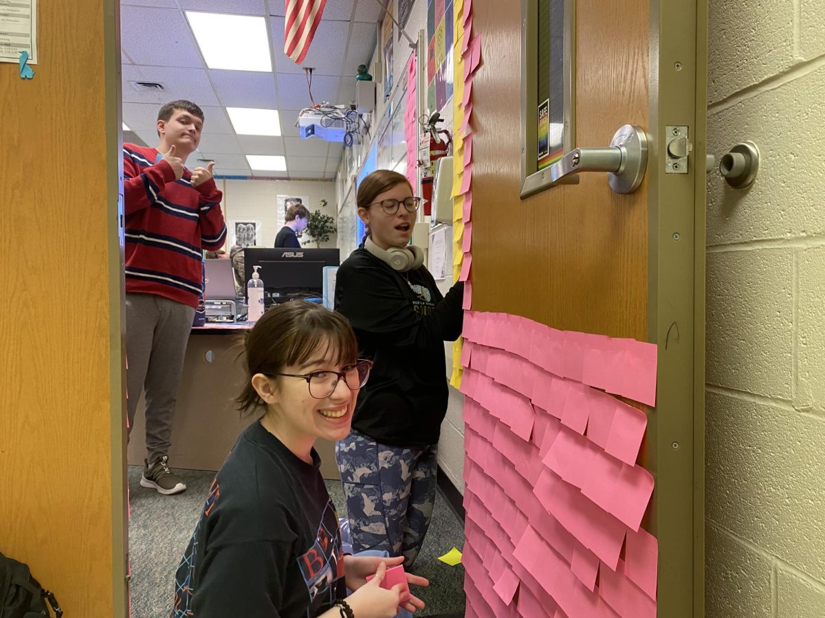 Morgan Hopper, Sarah Forrester, and Ben Lavalley begin the sticky note chaos as the line the door and wall in sticky notes. 