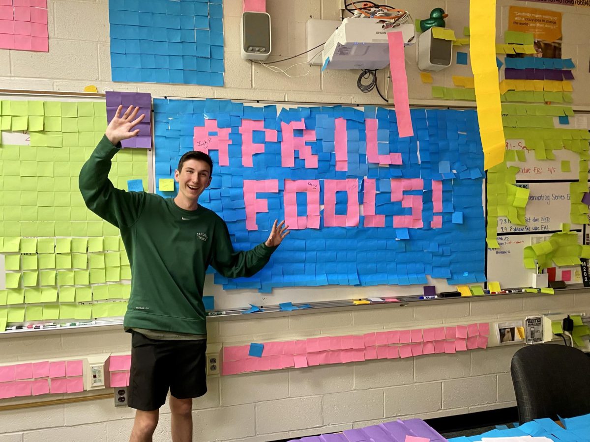 Jack Patton, who organized and funded this prank, stands proudly with the the April Fools' sign made of sticky notes. 