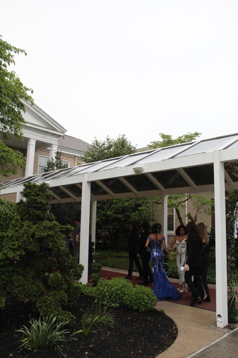 First few students walking into prom, getting out of the rain.