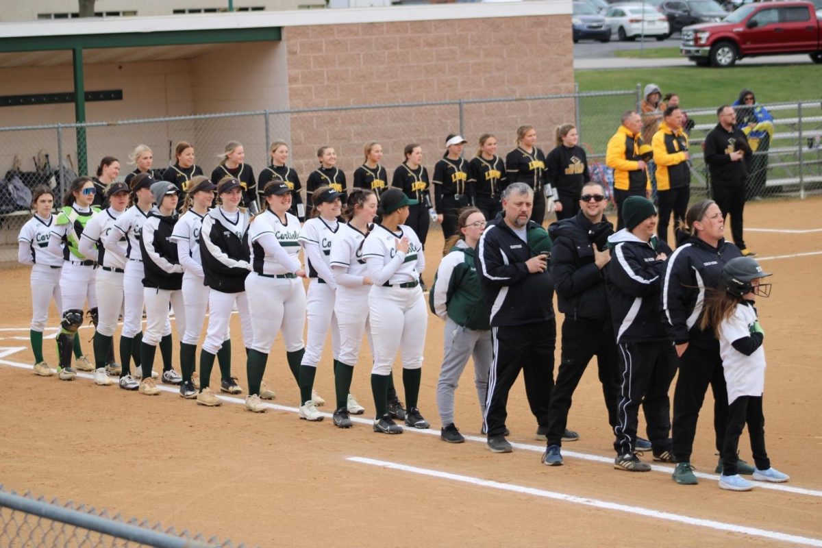 Please Rise: CHS softball team stands on the first baseline for the national anthem